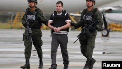 La policía colombiana escolta al narcotraficante Daniel "Loco" Barrera para abordar el avión de la DEA que lo trasladaría a Nueva York para entregarlo a las autoridades.
