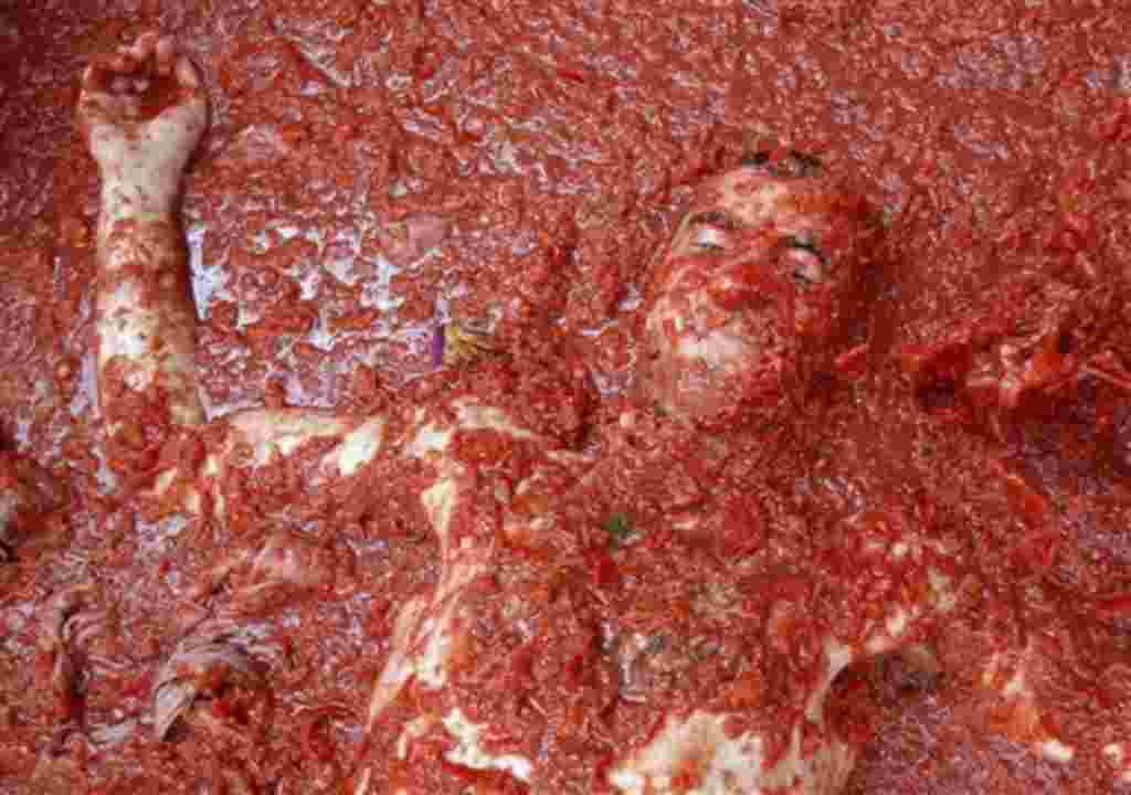 Gente de todas partes del mundo se lanza tomates durante la celebración de la 'Tomatina' en el pueblo de Buñol, cerca de Valencia, España.