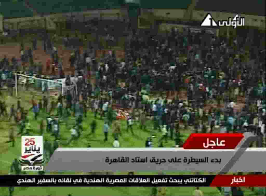 Gambar dari Egypt TV ini memperlihatkan para pendukung bentrok di stadion Port Said, Mesir (1/2) (AP).