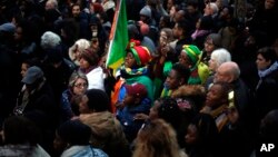 FILE: Protestors attend a demonstration against slavery in Libya outside the Libyan Embassy in Paris, Nov. 24, 2017. Interpol said 40 suspected human traffickers were arrested then and nearly 500 of their victims freed in a vast police operation in five African countries. 