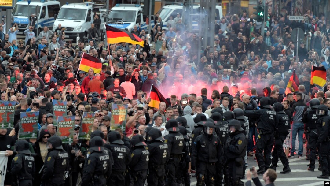 Para pengunjuk rasa dari kelompok ultra kanan menyalakan kembang api saat berdemonstrasi di Chemnitz, Jerman, Senin, 27 Agustus 2018.