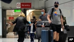 A woman runs to greet a child as passengers arrive at Terminal 5 of Heathrow Airport in London, Monday, Aug. 2, 2021. Travelers fully vaccinated against coronavirus from the United States and much of Europe were able to enter Britain without…