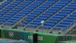 FILE - A worker inspects seats at Tokyo 2020 Olympic BMX Track in preparation for the Tokyo 2020 Olympic Games in Tokyo, Japan, June 30, 2021.