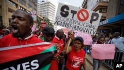 FILE - Kenyans carry placards during an anti-corruption demonstration by hundreds of protesters who marched to the Parliament and Supreme Court in downtown Nairobi, Kenya, May 31, 2018. 