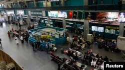 Passengers wait for their flights in the departure hall at Tripoli International Airport in Tripoli, Libya, March 21, 2014.