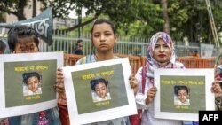 FILE - Bangladeshi women hold placards and photographs of schoolgirl Nusrat Jahan Rafi at a protest in Dhaka, April 12, 2019, following her murder by being set on fire after she had reported a sexual assault.