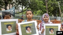 FILE - Bangladeshi women hold placards and photographs of schoolgirl Nusrat Jahan Rafi at a protest in Dhaka, April 12, 2019, following her murder by being set on fire after she had reported a sexual assault.