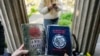 FILE - A woman holds copies of "The Satanic Bible" by Church of Satan founder Anton Szandor LaVey and "The Bible of the Adversary" by Michael Ford, before the start of a ceremony at the General Cemetery in Santiago, Chile, Sept. 14, 2024.