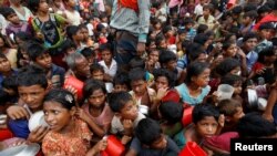 FILE - Rohingya refugee children wait to receive food outside the distribution center at Palong Khali refugee camp near Cox's Bazar, Bangladesh, Nov. 17, 2017. 