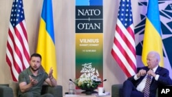 President Joe Biden, right, looks to Ukraine's President Volodymyr Zelenskyy as he speaks during a meeting on the sidelines of the NATO summit in Vilnius, Lithuania, Wednesday, July 12, 2023.