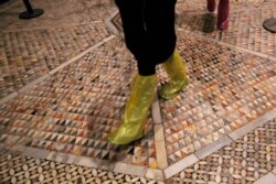 People walk on an interior mosaic floor of the St. Mark's Basilica in Venice, Italy, Tuesday, Dec. 17, 2019.