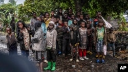 FILE - Congolese children watch the deployment of government and U.N. troops outside Goma, Democratic Republic of Congo, Jan. 24, 2025, as M23 rebels are reported to be closing in on the town. 