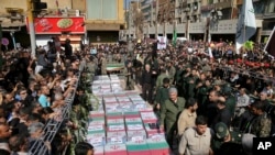 FILE - Flag-draped caskets of those who died in the Sept. 22 attack on a military parade are laid out during a mass funeral, in the southwestern city of Ahvaz, Iran, Sept. 24, 2018. 