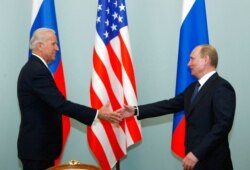 FILE - Joe Biden (left), then vice president of the United States, shakes hands with Russian Prime Minister Vladimir Putin in Moscow, March 10, 2011.