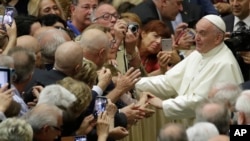 Pope Francis greets members of an association of people honored by the Italian presidency for their commitment to their work, in the Paul VI Hall at the Vatican, June 15, 2018.