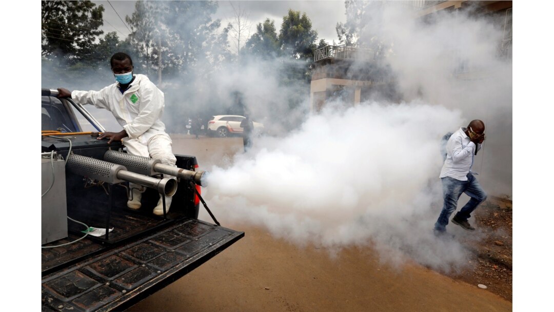 A man walks through smoke generated by Nairobi municipality worker in an effort to fight against the spread of the coronavirus disease (COVID-19) in the Kawangware neighborhood of Nairobi, Kenya, May 2, 2020.