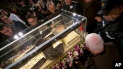 People stand around the mortal remains of Saint Pio (Padre Pio) as they are displayed in Rome's San Lorenzo Basilica, as part of the Roman Catholic Church 2016 Holy Year celebrations, Feb. 3, 2016.