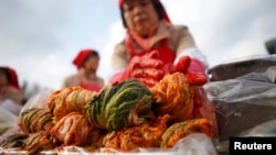 A woman makes traditional Korean side dish kimchi, or fermented cabbage, during the 2014 Seoul Kimchi Making and Sharing Festival at Seoul City Hall Plaza in Seoul, South Korea, Nov. 14, 2014. 