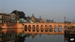 People stand on a bridge in Ayodhya, India. Schools, shops and businesses reopened in Ayodhya and other places following a court order to divide a disputed holy site between the Hindu and Muslim communities, 02 Oct 2010