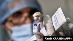 На фото: медик в Алжирі тримає ампулу вакцини "Спутнік V"