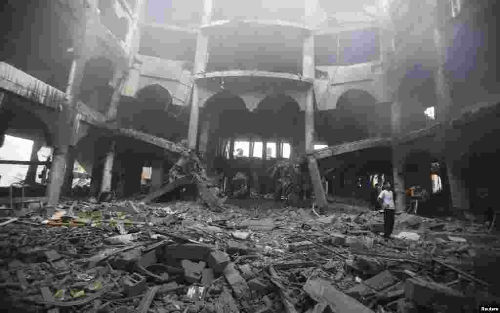 A Palestinian looks at the remains of a commercial center, which witnesses said was hit by an Israeli airstrike on Saturday, in Rafah in the southern Gaza Strip, Aug. 24, 2014. 