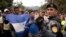 Honduran migrants walking in a group stop before Guatemalan police near Agua Caliente, Guatemala, Jan. 16, 2020, on the border with Honduras.