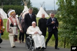 Pope Francis leaves with Indigenous peoples after praying in a cemetery at the former residential school, in Maskwacis, near Edmonton, Canada, Monday, July 25, 2022. (AP Photo/Gregorio Borgia)