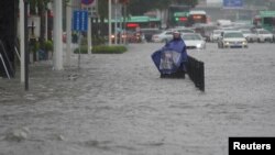 Banjir menggenangi jalanan di kota Zhengzhou, Henan, China Selasa (20/7). 