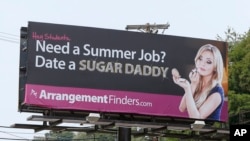 A billboard that a Toronto company says is meant to connect female college students with "sugar daddies" who pay a fee to join its website service is seen on Wednesday, July 10, 2013, in Pittsburgh.