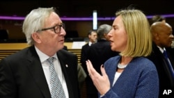 European Union foreign policy chief Federica Mogherini, right, speaks with European Commission President Jean-Claude Juncker during a round table meeting of the EU-Sahel at EU headquarters in Brussels, Feb. 23, 2018. 
