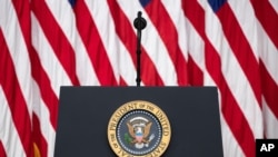 FILE - The presidential podium and seal are seen before an event in the South Court Auditorium of the White House complex, in Washington, July 24, 2020. 