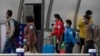 Returnees from the Hubei Province leave from the West Train Station to board buses in Beijing on March 26, 2020.