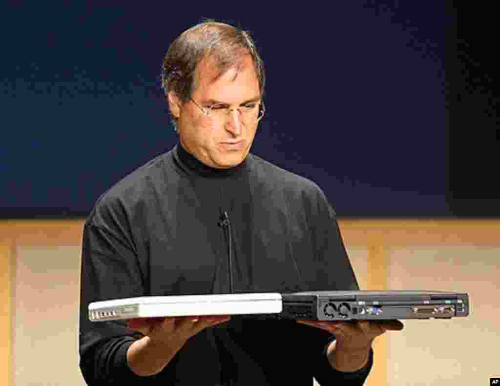 Steve Jobs compares the weight of the all new iBook notebook computer weighing just 4.9 pounds (L) and a Dell computer notebook during a Apple Media event in Cupertino, California 01 May 2001. (AFP)