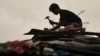 A resident reinforces his roof in Santa Ana, Cagayan Province, northern Philippines as they anticipate Typhoon Usagi to hit their area Nov. 14, 2024.