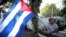 A man waves a Cuban flag while celebrating the restoration of diplomatic relations between Havana and Washington, in the courtyard of the Cuban Embassy in Santiago, Chile, Dec. 17, 2014.