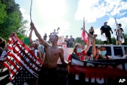 Native American protesters form a roadblock on the road leading to Mount Rushmore ahead of President Donald Trump's visit to the memorial on Friday, July 3, 2020, in Keystone, S.D. (AP Photo/Stephen Groves)