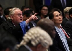 William Schabas, a Canadian attorney defending Myanmar against genocide charges at the U.N.'s International Court of Justice and Myanmar's leader Aung San Suu Kyi attend a hearing in a case filed by Gambia, Dec. 11, 2019.