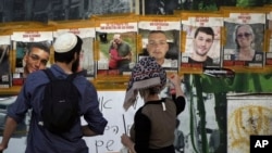 FILE - People look at pictures of Hamas hostages, including Itay Svirsky, second from right, in Jerusalem, May 25, 2024.