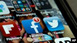 FILE - An iPhone screen is seen with Twitter, Facebook, and other apps in a May 21, 2013, photo.