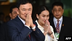 FILE - Former Thai Prime Minister Thaksin Shinawatra greets supporters with his daughter Paetongtarn Shinawatra after landing at Bangkok's Don Mueang Airport on Aug. 22, 2023.