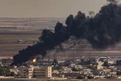 FILE - In this photo taken from Ceylanpinar, Sanliurfa province, southeastern Turkey, smoke billows from fires on targets in Ras al-Ayn, Syria, caused by bombardment by Turkish forces, Oct. 13, 2019.