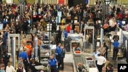 Travelers wade through the south security checkpoint in Denver International Airport, Dec. 19, 2024, in Denver, Colorado.