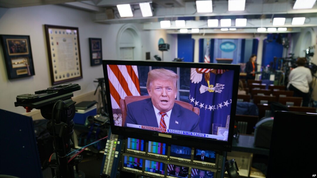 Predsjednik Donald Trump vidi se na ekranima u sobi za brifinge Bijele kuće, dok se u udarnom terminu obraća naciji iz Ovalnog kabineta, 8. januara 2019.