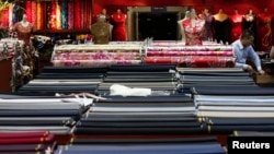FILE - An employee works in a clothing shop in Beijing, China.