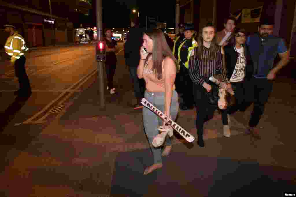 Concert goers react after fleeing the Manchester Arena in northern England where U.S. singer Ariana Grande had been performing in Manchester, Britain, May 22, 2017. 