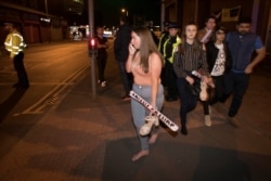 FILE - Concert goers flee the Manchester Arena in northern England where US singer Ariana Grande had been performing in Manchester, Britain, May 22, 2017.