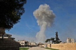 Smoke billows over the town of Saraqib in the eastern part of the Idlib province in northwestern Syria, following bombardment by Syrian government forces, on February 27, 2020.