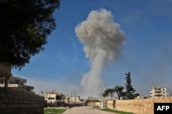 Smoke billows over the town of Saraqib in the eastern part of the Idlib province in northwestern Syria, following bombardment by Syrian government forces, on February 27, 2020.
