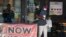 A customer walks past a now hiring sign at an eatery in Richardson, Texas, Sept. 2, 2020. 