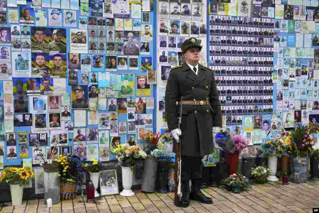 A soldier stands in front of The Wall of Remembrance of the Fallen for Ukraine at St Michael&#39;s Square in Kyiv, Ukraine.